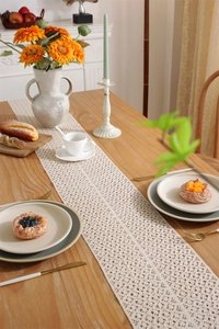 Detailed view of cream crochet lace table runner with intricate hollowed patterns