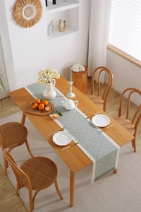 Detail view of jacquard table runner with geometric patterns and fringe tassels