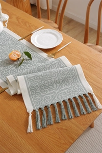 Detail of bohemian jacquard table runner with geometric patterns and tassel fringe edge