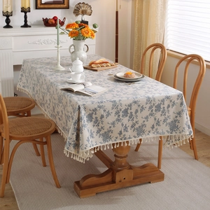 Tovaglia floreale impermeabile con motivi blu ed eleganti frange su un tavolo di legno