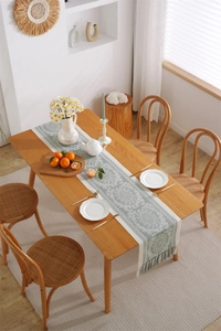 Close-up of Morandi green floral table runner with handmade tassels on wooden dining table