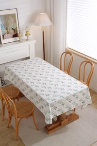 Close-up of French floral cotton tablecloth with leaf print on a wooden dining table