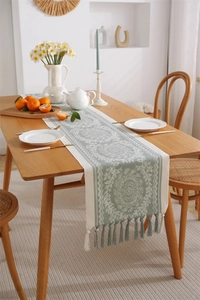 Detail of bohemian jacquard table runner featuring geometric patterns and hanging tassels