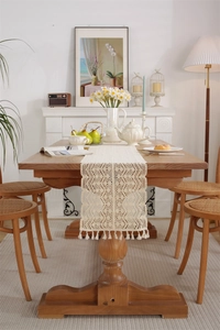Detailed macro of pastoral crochet table runner with delicate tassels and hollow weave pattern