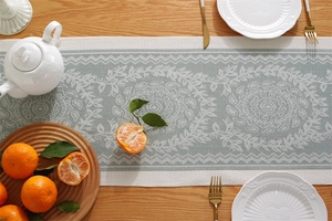 Detailed macro of vintage floral jacquard table runner on a warm wooden surface