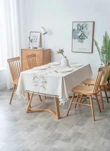 Detail of embroidered floral pattern and fringe edge on linen rectangular tablecloth