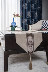 Detail of New Chinese style table runner with traditional longevity patterns and brown tassels