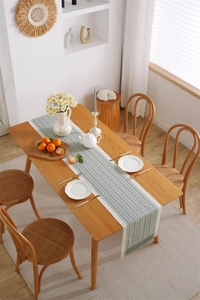 Detail of jacquard woven table runner with geometric patterns and fringe tassels