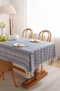 Detailed view of bohemian table runner with gray-blue geometric patterns and white tassels