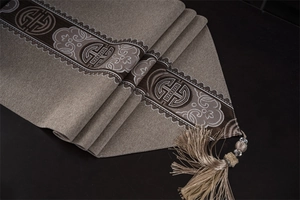 Detail of traditional Chinese table runner featuring woven jacquard patterns and silk tassels
