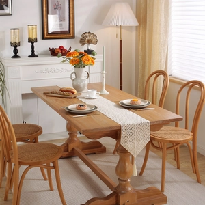 Vintage crochet hollow lace table runner with tassels on a rustic wooden dining table
