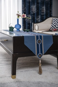 Detailed embroidery and brown tassels on a dark blue traditional Chinese table runner