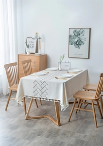 Detail of bohemian tablecloth featuring woven geometric stripes and white tassel fringes