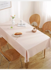 Detail of pink waterproof PVC tablecloth draped over a dining table with modern home decor