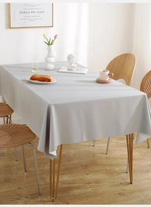 Close-up of grey waterproof PVC tablecloth with soft drape on a modern dining table
