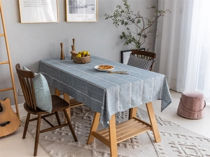 Blue jacquard tablecloth with white stripes showing drape on a rectangular wooden table