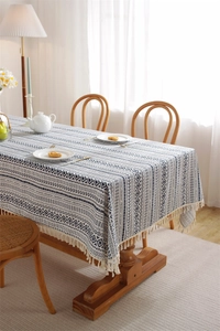 Detail of bohemian geometric tablecloth featuring fringe edges on a dining table