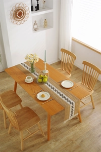 Detail of bohemian woven table runner featuring black diamond patterns and white fringe