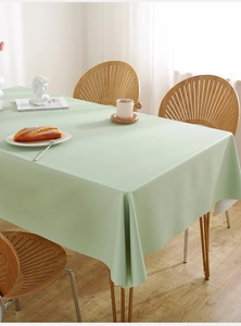 Close-up of mint green waterproof PVC tablecloth with soft leather texture on a wood table