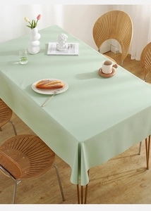 Detail of mint green waterproof PVC tablecloth with soft drape on a wooden table