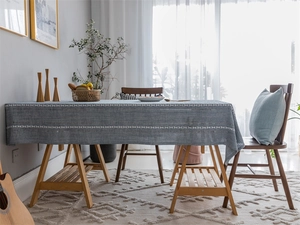 Detail of blue-grey jacquard tablecloth with white braided texture and elegant drape
