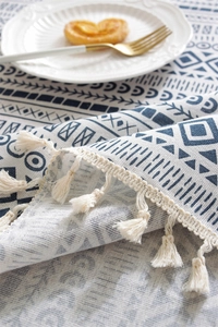 Macro shot of bohemian geometric table cloth with blue patterns and cotton tassels