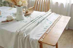 Close-up of floral embroidery and fringe edge on cream waterproof tablecloth