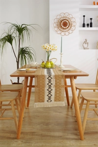 Close-up of bohemian table runner with geometric diamond patterns and tassel details
