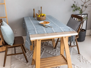 Detailed close-up showing blue-grey jacquard textured tablecloth with white braided pattern