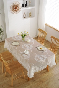 Nahaufnahme der weißen französischen Spitzentischdecke mit floraler Stickerei und Wellenrand
