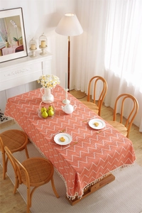 Detail of orange and white chevron bohemian tablecloth with white tassel fringe edges