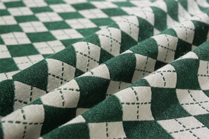 Dettaglio del motivo a rombi verde retrò sul tessuto della tovaglia in misto cotone