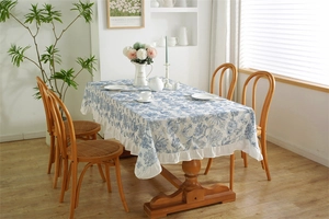 Detail of blue and white floral cotton tablecloth with elegant ruffled edge decoration