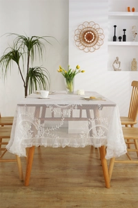 Nahaufnahme der weißen Spitzentischdecke mit Blumenstickerei und eleganten Rüschen