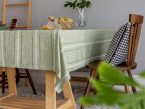 Detail of green polyester jacquard tablecloth with white woven geometric braid patterns