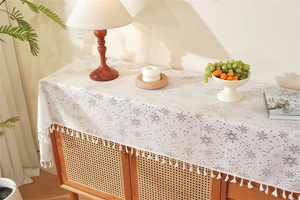 Detailed view of white lace table runner with snowflake jacquard patterns and tassels