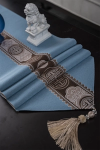 Detail of grey-blue Chinese style table runner with traditional jacquard and tassel