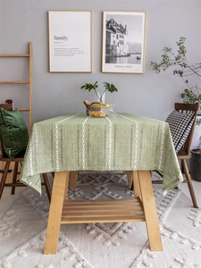 Detailed macro view of light green jacquard tablecloth with white stripes and woven texture