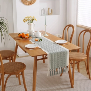 Green and white jacquard table runner with leaf patterns and elegant handmade tassels