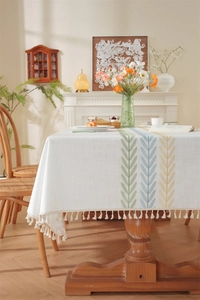 Detailed texture of cotton linen tablecloth featuring colorful embroidery and beige tassels