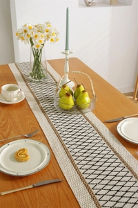 Detailed knit texture of a cotton linen table runner with black diamond geometric patterns
