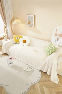 Close-up of cream white thick plush sofa cover with embossed diamond jacquard texture