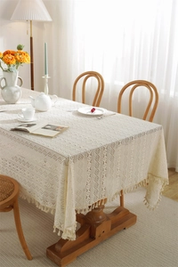 Detailed view of beige lace tablecloth featuring geometric hollow weaving and tassel edges