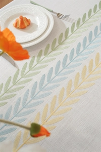 Detail of floral embroidery on waterproof linen tablecloth with rustic dining table decor