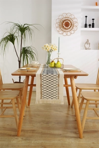 Detail of woven table runner with black diamonds, brown stripes, and tassel fringe
