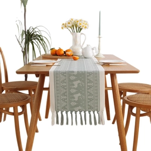 Sage green Christmas table runner with knitted reindeer pattern and tassel edges