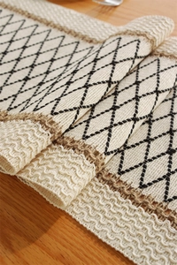 Detail of bohemian cotton linen table runner with black geometric diamond embroidery