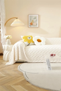 Detail of plush cream sofa cover showing 3D geometric jacquard texture and soft thick fabric