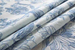 Detailed embroidery of blue floral patterns on premium waterproof cotton tablecloth fabric