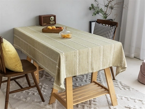 Macro detail of green woven polyester jacquard tablecloth with geometric stripe patterns